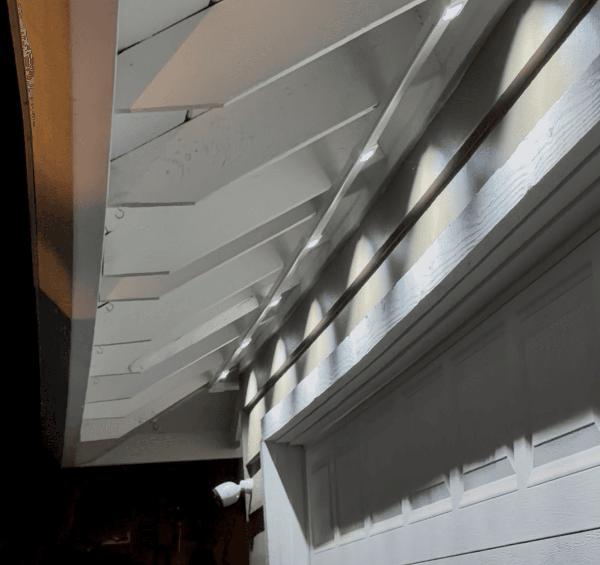 Close-up of PermTrack channel mounted along exposed rafter tails with evenly-spaced Govee LEDs
